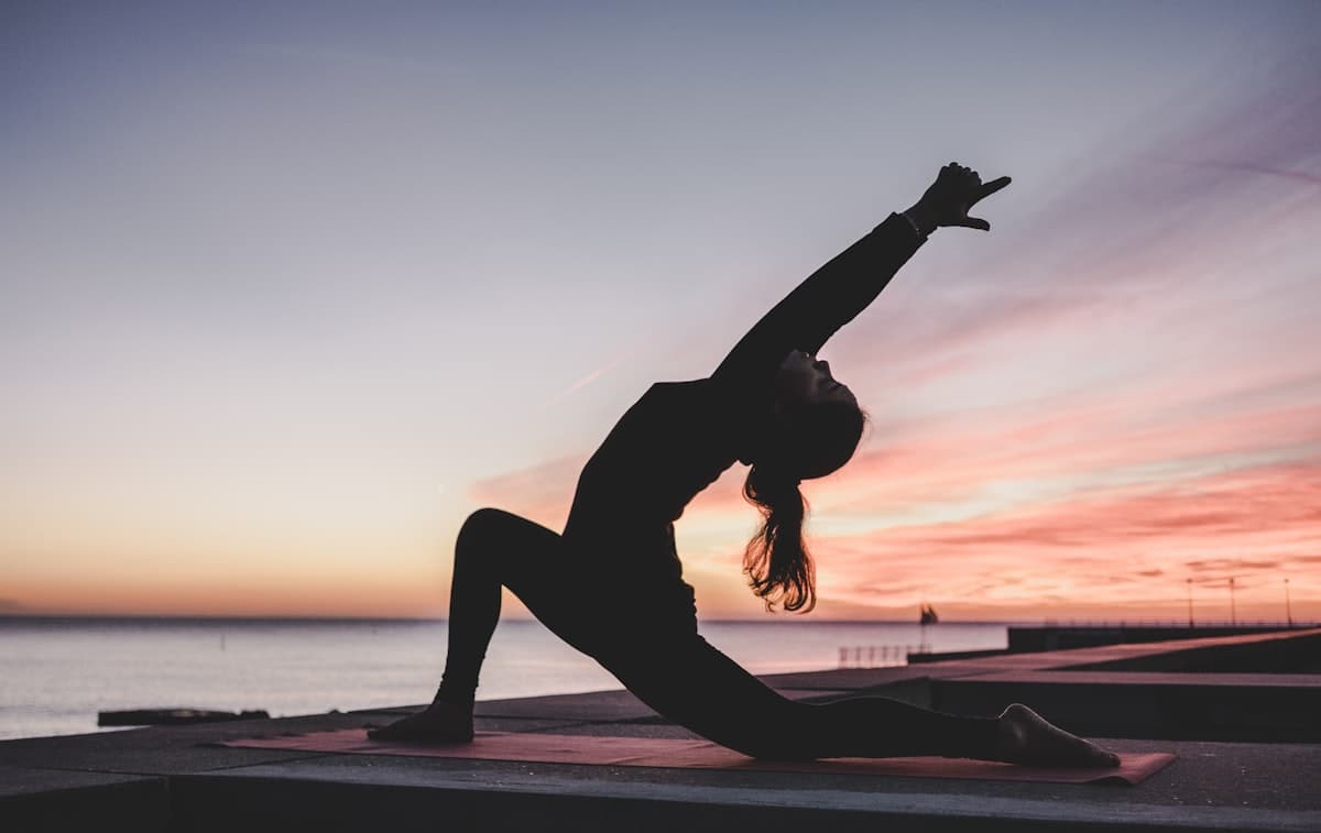A person practicing yoga at sunset